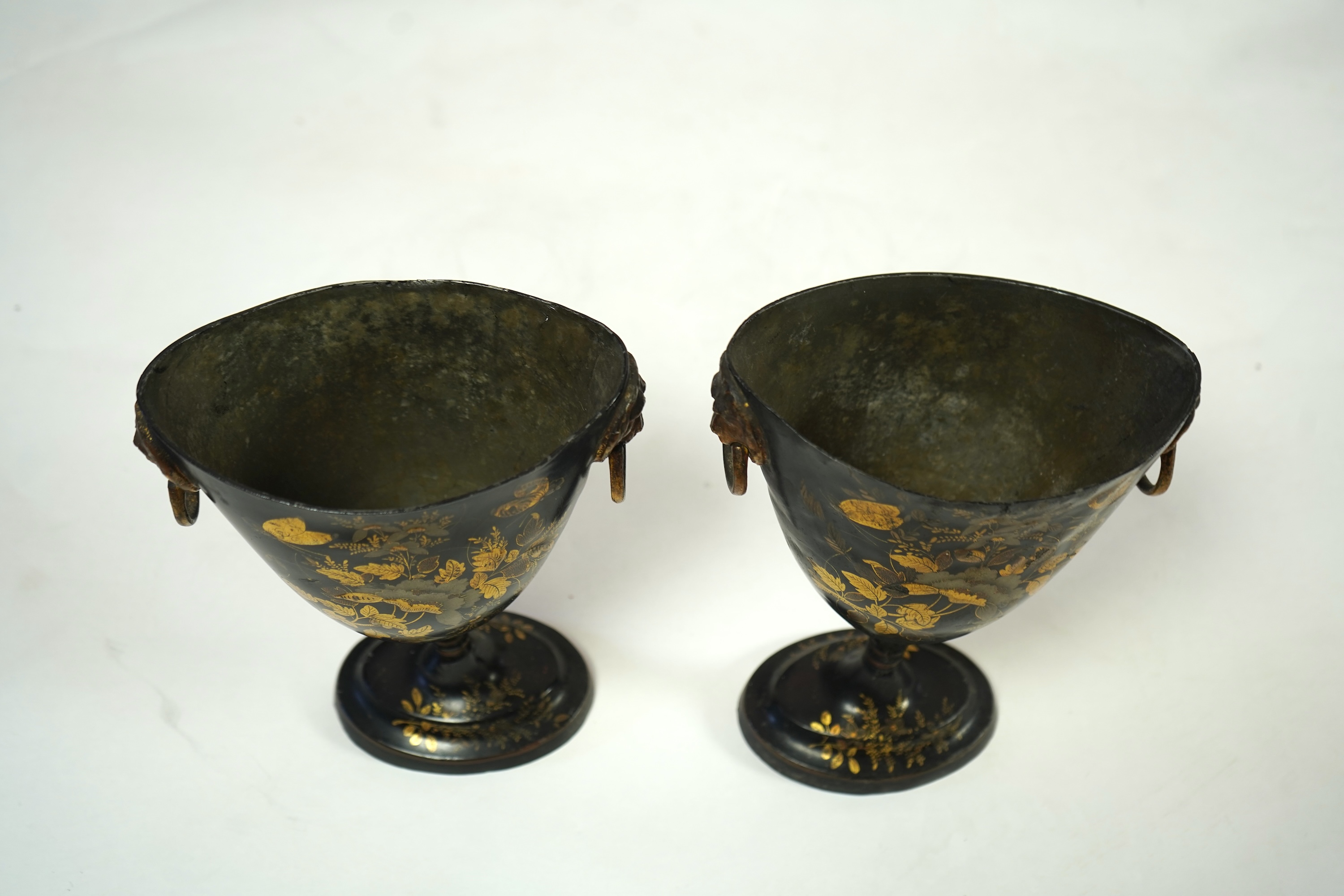 A pair of early 19th century Dutch japanned pewter chest urns and covers, and a tole ware cheese coaster